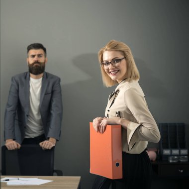 İş kadını gülümseme ile office arka planda sakallı adam. İş kadını anlaşma önce evrak var