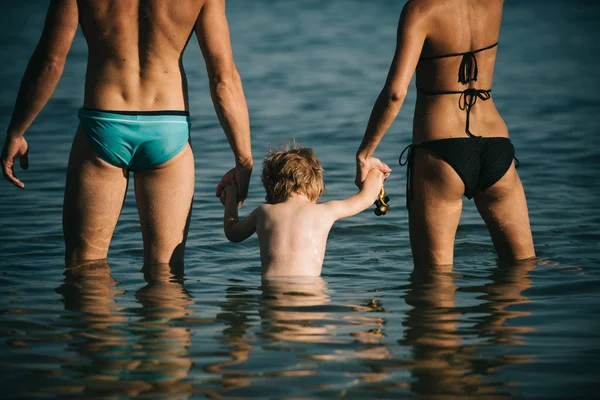 Famiglia felice in mare divertendosi in acqua, madre e padre con bambino godendo località balneare in vacanze estive, concetto di vacanza . — Foto Stock