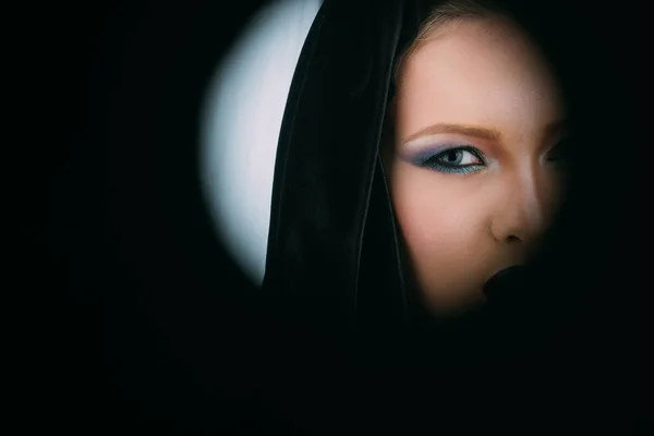 Vacker kvinna med svart kappa över svart bakgrund, kopiera utrymme. — Stockfoto