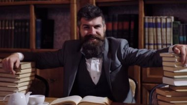 Saygın bir adam kütüphanede masada oturan duygular çeşitli gösterir. Duygular, bilim, Kütüphane kavramı. Bilimsel alt.