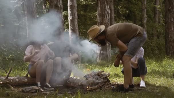 Jóvenes acampando. Grupo de amigos acampando. Están sentados alrededor del fuego del campamento. — Vídeo de stock