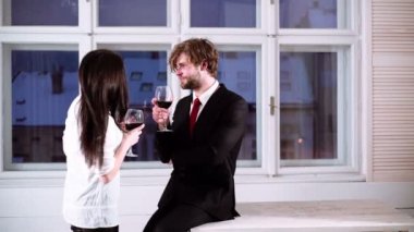 Romantik Çift kırmızı şarap içme. Güzel genç bardak kırmızı şarap ile çift. Genç romantik çift bardak kırmızı şarap ile kutluyor