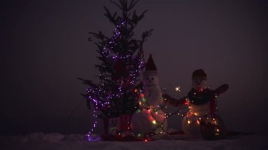 Kar adam karda Noel hediyesi. Kışın Noel yatay duran iki kar adam