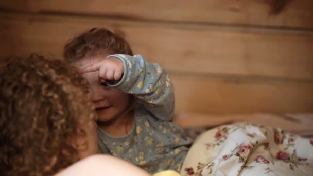 Boa noite, hora de dormir. Família mãe e filho lêem um livro à noite em casa. Filho e mãe são felizes juntos. Mãe contando história para filho na hora de dormir — Vídeo de Stock