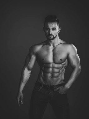 Spor ve egzersiz. Atletik vücut geliştirmeci adam siyah arka plan üzerine.