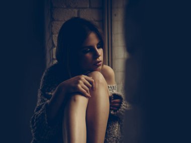 Kız güzel kız ile pencere pervazına, bacaklarına otur. Genç yüz makyaj ile kız