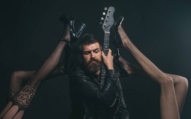 Müzik tutkusu var. Gitar Fetiş iç çamaşırı seksi bacaklar tarafından cazip olan sakallı adam. Seksi hissediyor. Rock yıldızı gibi. Çekici ve seksi
