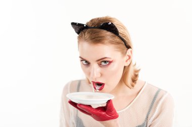 Yavru kedi kulakları ve kırmızı üzerine beyaz izole yoğurt eldivenlerle kız. Seksi kedi kadın yalamak süt plaka. Yiyecek ve içecek. Kedi kadın ye ekşi krema. Diyet ve sağlık. Ekoloji ürün ve heath.