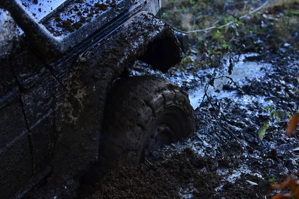 Araba parçası kir içinde sıkışmış, yakın çekim.