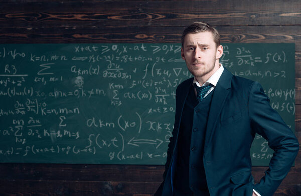 Talented mathematician. Teacher smart student intrested math physics exact sciences. Man formal wear classic suit looks smart, chalkboard with equations background. Genius solved mathematics problem