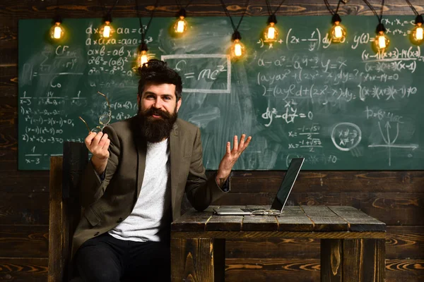 Neşeli freelancer laptop önünde oturan, seyir ve neşeli ifade başarılı işten sonra kamerayla gülümseyen casual elbise giymiş