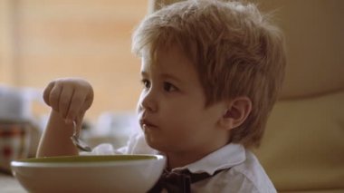 Küçük çocuk onun yulaf lapası zevk. Komik çocuk süt ile yulaf lapası yemek. Bebek maması, Bebek yeme