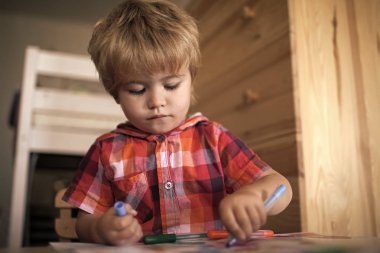 Çocuk keçeli kalemler ile boyar. Çocuk veya keçeli kalem ile sarışın mutlu çocuk boyama.