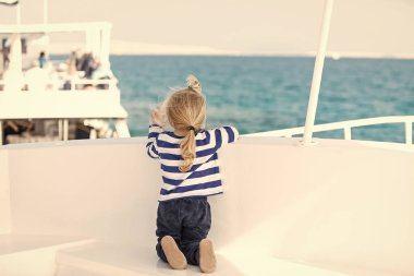 Yat ve yelken. Arka beyaz yatta oturma küçük şirin çocuk.