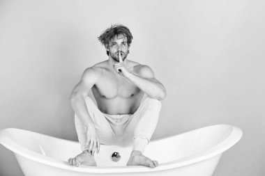 yakışıklı delikanlı ile kas vücut beyaz küvette oturarak