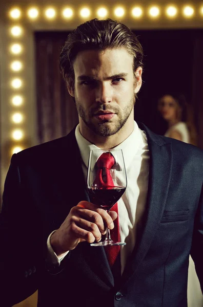 elegant man. with a glass of red wine. man hold wine glass, sommelier