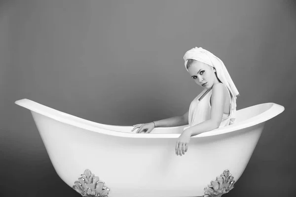 Concepto de moda femenina. mujer bastante sexy con turbante toalla sentado en bañera blanca — Foto de Stock