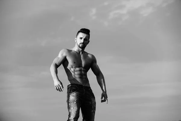 Uomo è un bodybuilder. uomo con corpo muscoloso su cielo blu — Foto Stock