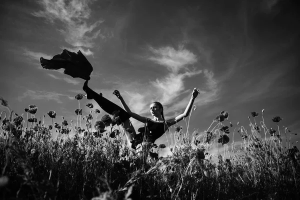 Modische Frau posiert. hübsches Mädchen im Blumenfeld aus Mohn — Stockfoto