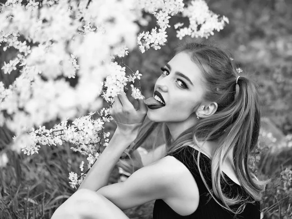 Tjej slickar blommor. Söt tjej i blossom — Stockfoto