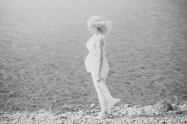 Bela mulher grávida. Mulher grávida em vestido branco andando na praia do mar — Fotografia de Stock