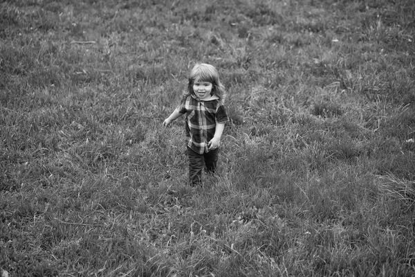 子供のプレー - 幸せなゲーム。緑の芝生の上の小さな男の子 — ストック写真