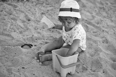 Çocuk kum havuzunda oynuyor. Plastik oyuncaklar ile kaplama çocuk