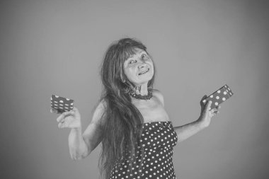 Yaşlı kadın hediye kırmızı arka plan ile. Uzun kızıl saçlı kadın renkli kutu tutun. Mutlu kadın elinde hediye.