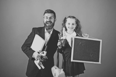 Okula gitme zamanı. Mikroskop, yazı tahtası, kitap ve Kırtasiye çocuk ve eğitmen tutun