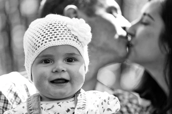 Fullfjädrad lycklig familj. Flicka och kysser föräldrar — Stockfoto