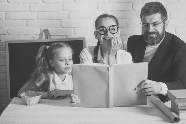 Familjutbildning hemma. Kid, äldre syster och handledare i glas med glada miner — Stockfoto