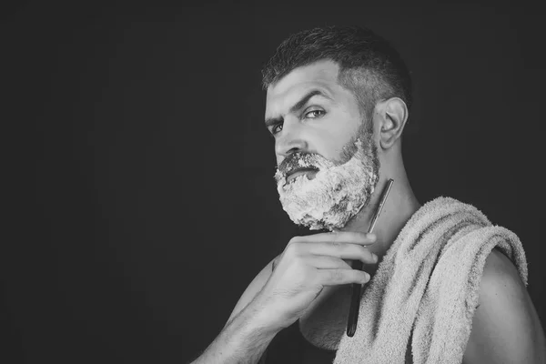 man shaves his beard. Man cut beard and mustache with razor and shaving brush