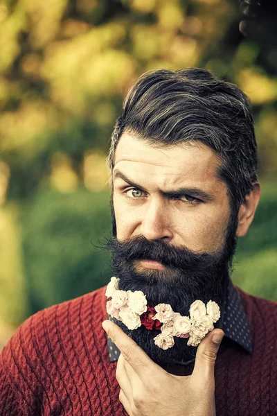 Belleza hombre modelo de moda. Mirada de moda. Hombre con flores en la barba — Foto de Stock