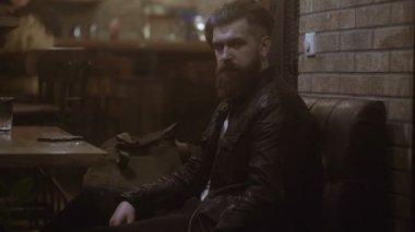 Mutlu genç adam yanında smartphone kafede oturan konuşma. Genç işadamı kafede telefonda konuşuyor