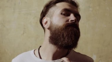 Yakışıklı, gülümseyen genç adam modern saç stili yapıyor.