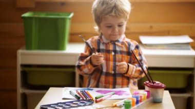 Çocuk Yaratıcılık Eğitim Konsepti, Çocuk Öğrenme Sanatı. Anaokulu çocuğu kreşte renkli boyalarla eğleniyor. Yaratıcı çocuk evde resim çiziyor. Çocuklar anaokulunda oynarlar.