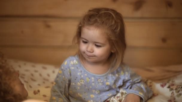 Família mãe e filho lêem um livro à noite em casa. Filho e mãe são felizes juntos. Mãe contando história para filho na hora de dormir. História de família hora de dormir . — Vídeo de Stock