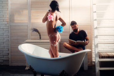 Masaj ve aile spa kavramı. Seks oyunları arzu ve orgazm. Çift banyo ilişkileri köpük ile seviyorum. Çıplak kız yıkama iken WISP ile sakallı adam kitabını okudum. Seksi vücut aşık çift.