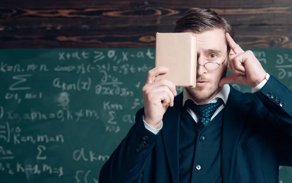 Denken Sie daran. Lehrertracht und Brille sehen pfiffig aus, Kreidehintergrund. Mann unrasiert hält Buch vor Gesicht. Lehrer beharrt auf Informationsbedarf. Bildungskonzept — Stockfoto