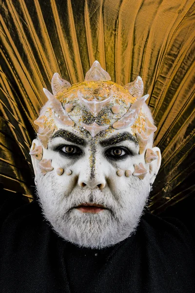 Dikenler veya siğiller, baş yüz pırıltılar ile kaplı, yakın çekim. Uzaylı, iblis büyücü makyaj. Sakallı canavar makyaj ile komuta sizde. Fantezi kavramı. Altın yaka, siyah arka plan ile iblis