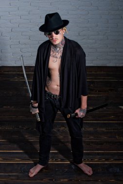 Savaşçı siyah şapka ve dövmeli gövde gösterilen açık giyim