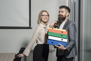 Office klasörlerinde yığını taşıyan meslektaşı ile neşeli işkadını