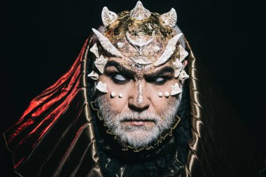 İblis dikenli yüz ve siyah arka plan üzerine metalik kaputu giyen parlak cilt üzerinde. Cehennemden, korku kavramı yükselterek boynuzlu şeytan