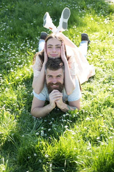 Aproveite as férias de verão. Casal feliz relaxar ao ar livre ensolarado. Mulher sensual deitada no homem barbudo na grama verde. Tempo despreocupado juntos. Casal apaixonado — Fotografia de Stock