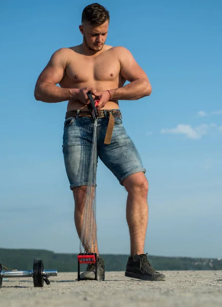 Muskeltraining und Muskelaufbau. Sportler bauen Muskeln mit Widerstandsband auf. Muskelmann in Ganzkörper am blauen Himmel. Mann mit Sixpack Muskeln. Körperfett verbrennen, bevor es der Gesundheit schadet — Stockfoto