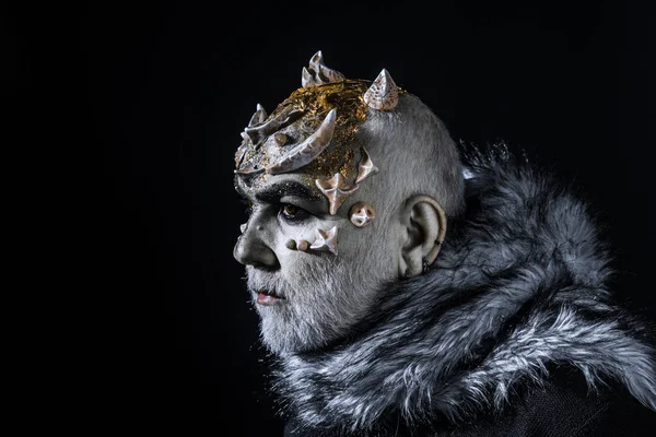 Alienígena, demónio, maquilhagem de feiticeiro. Demônio no fundo preto, espaço de cópia. Conceito de maquiagem teatral. Homem sénior de barba branca vestido de monstro. Homem com espinhos ou verrugas em casaco de peles — Fotografia de Stock