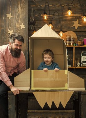 Amerikan rüyası. Baba, Baba, küçük kozmonot ile Çocuk oyun karton kutudan yapılan roket oturup. Çocuk şirin çocuk oyun kozmonot, astronot. Çocuk mutlu oturmak karton el roket yapımı. Roket