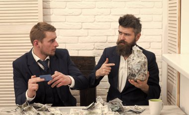 İş ve finans. İş ortakları, office toplantıda işadamları. Sakallı patron kavanoz dolusu para tutar, meslektaşım kredi kartı almıştır. İş kar, kavanoz veya banka hesabı para tutmak. Nakit