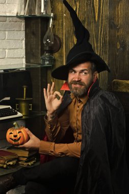 Cadılar Bayramınız Kutlu Olsun. Cadılar Bayramı Sihirbazı ile kabak ahşap duvar üzerinde gülümseyen