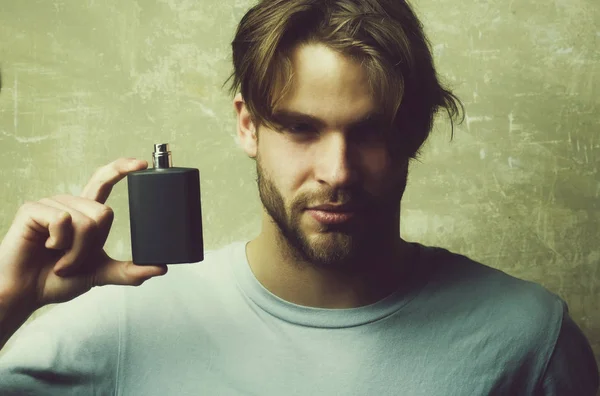 Colónia masculina. cara com frasco de perfume preto — Fotografia de Stock